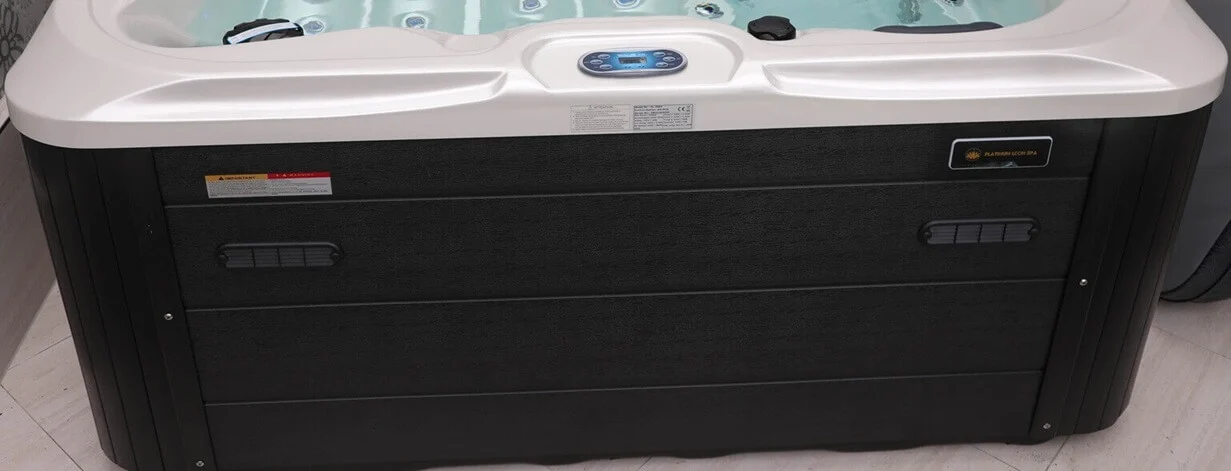 Cadă cu hidromasaj compactă HOME 210×160×77 cm, cu carcasă neagră și suprafață acrilică albă, având un panou de control digital pe partea superioară și un design simplu, potrivit pentru spații interioare sau exterioare mici.